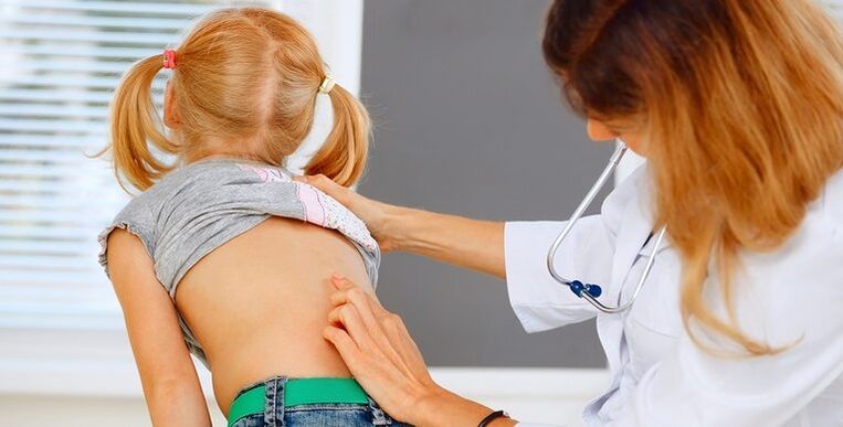 medic care examinează spatele unui copil pentru dureri de spate